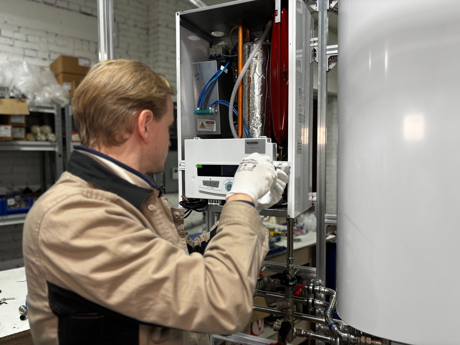 Technicien installant ou réparant un système de chauffage dans un atelier.